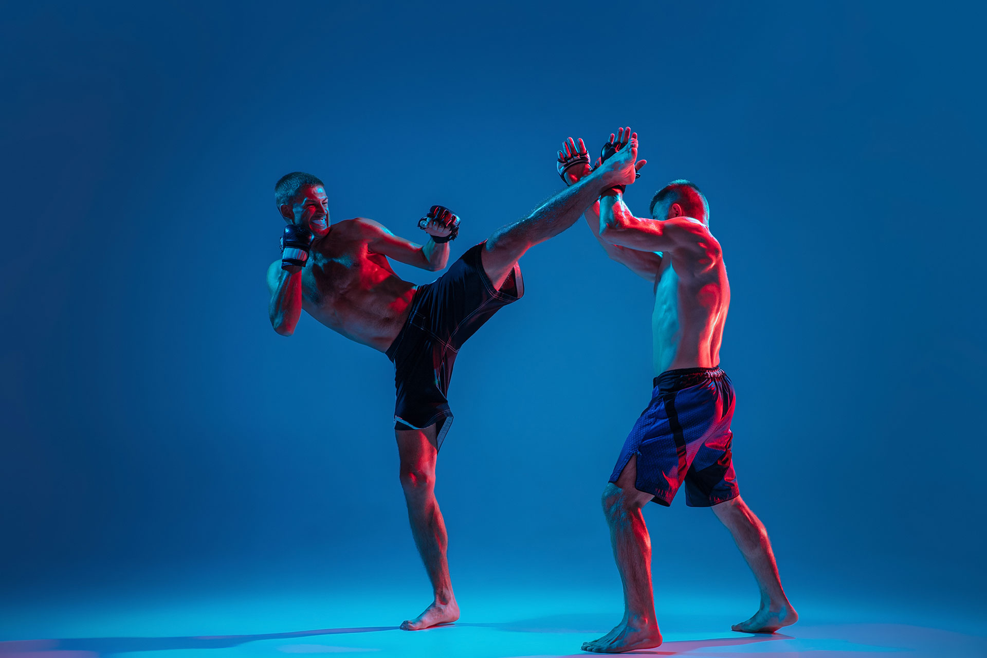 mma-two-professional-fighters-punching-boxing-isolated-blue-wall-neon-(1)